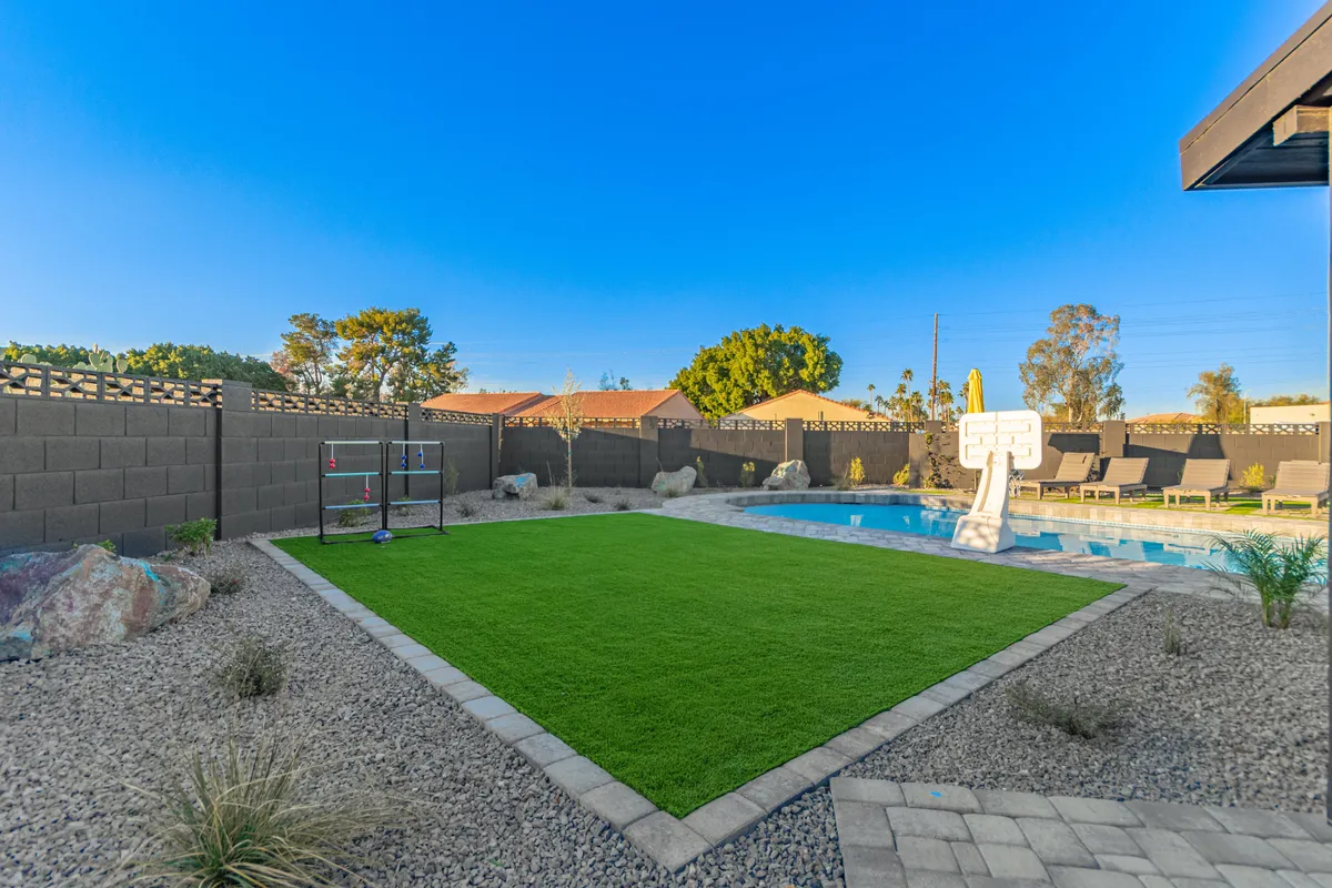 This exterior image spotlights a swimming pool paired with a basketball hoop, a landscaped lawn, and barbecue setup—conveying a playful, active atmosphere for swimming, friendly competitions, and outdoor parties.